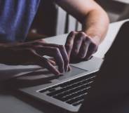 A white person is on a computer watching something on the screen