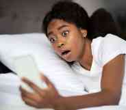 Shocked young woman laying in bed