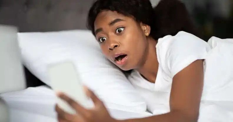 Shocked young woman laying in bed