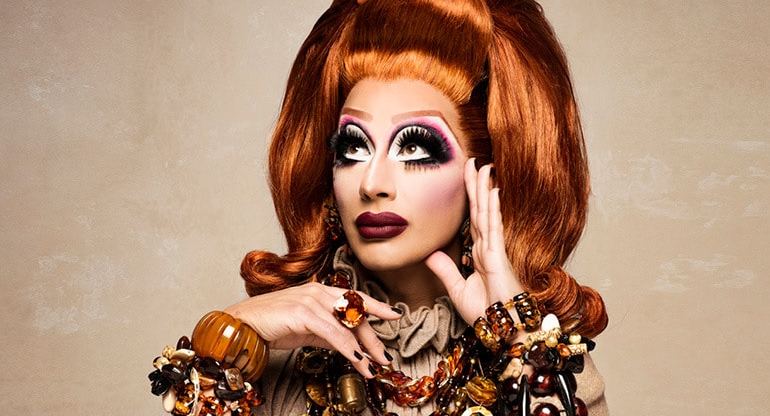 A promo image of drag queen Bianca Del Rio wearing an orange wig and dress