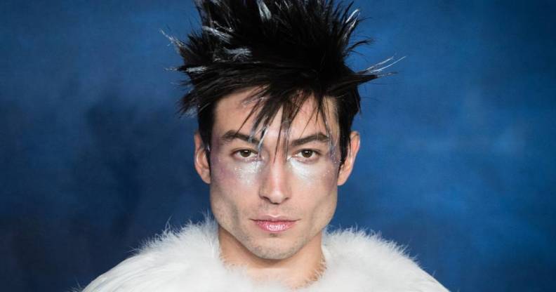 Actor Ezra Miller is seen wearing a white fluffy outfit with silver makeup and fluffy dark hair with white tips