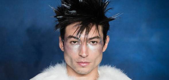 Actor Ezra Miller is seen wearing a white fluffy outfit with silver makeup and fluffy dark hair with white tips