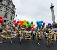 Revellers carry a Disney logo during the Pride in London parade on 06 July, 2019 in London, England