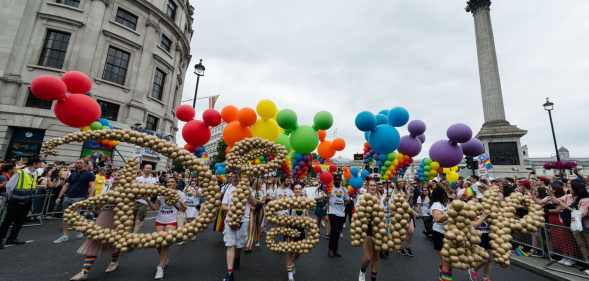 Revellers carry a Disney logo during the Pride in London parade on 06 July, 2019 in London, England