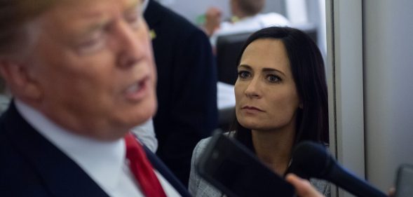 Former White House press secretary Stephanie Grisham listens as ex-president Donald Trump speaks to the media