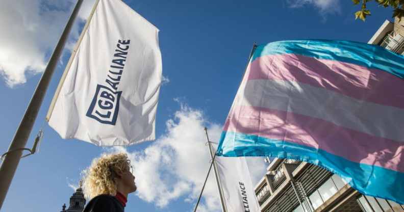 An activist holds a transgender pride flag at a protest by Transgender Action Block and supporters outside the first annual conference of the LGB Alliance at the Queen Elizabeth II Centre on 21st October 2021.