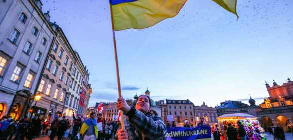 A protester waves a Ukrainian flag during a protest in Krakow, Poland.