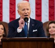 President Joe Biden stands at a podium to deliver his State of the Union address with an American flag in the background