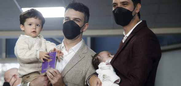Same-sex newlyweds Jaime Nazar (L) and Javier Silva (R) pose whole holding their two kids