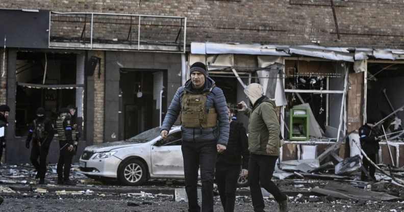 Kyiv's mayor Vitali Klitschko (C) walks in front of a destroyed apartment building, in Kyiv on March 14, 2022.