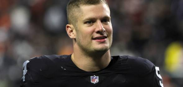 Carl Nassib, a player for the Las Vegas Raiders, walks off the field while wearing a football jersey