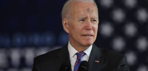 Joe Biden, the president of the United States, stands at a podium with an American flag in the background