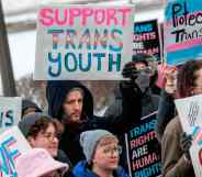 Person holds up a sign that reads "support trans youth" amid a rally in support of trans kids across the USA