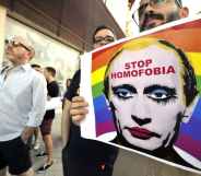 A demonstrator holds a poster depicting Russian President Vladimir Putin with make-up.