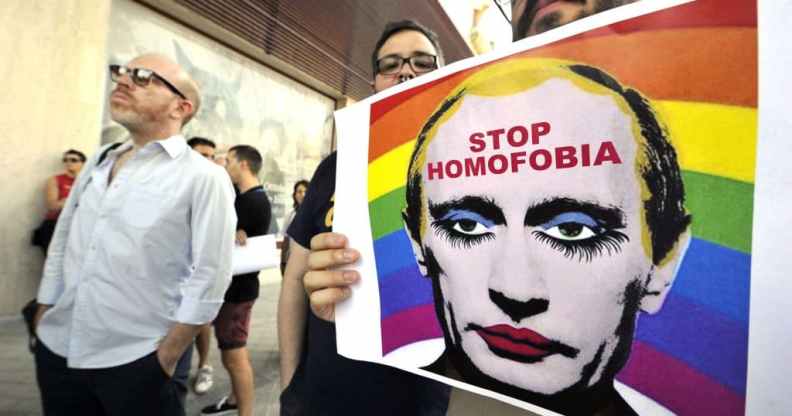 A demonstrator holds a poster depicting Russian President Vladimir Putin with make-up.