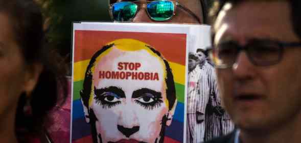A man showing a picture of Vladimir Putin during a protest supporting LGBT+ people in Chechnya
