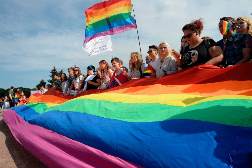 People wave gay rights' movement rainbow flags during the gay pride rally in Saint Petersburg, on Agust 12, 2017.