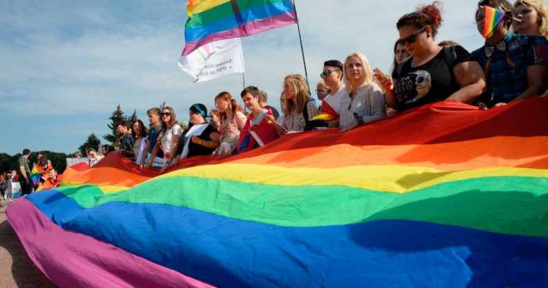 People wave gay rights' movement rainbow flags during the gay pride rally in Saint Petersburg, on Agust 12, 2017.