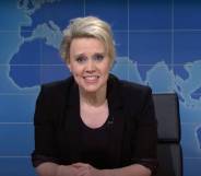 Kate McKinnon, a cast member of Saturday Night Live, wears a black outfit as she appears in front of a fake news desk set up on the show's Weekend Update segment