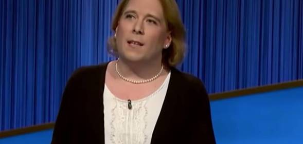 Amy Schneider wears a white top and black jacket as she appears on Jeopardy!