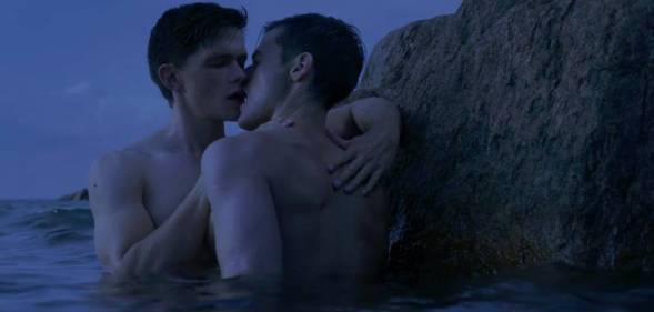 Two men are seen kissing while standing in water in the film Firebird