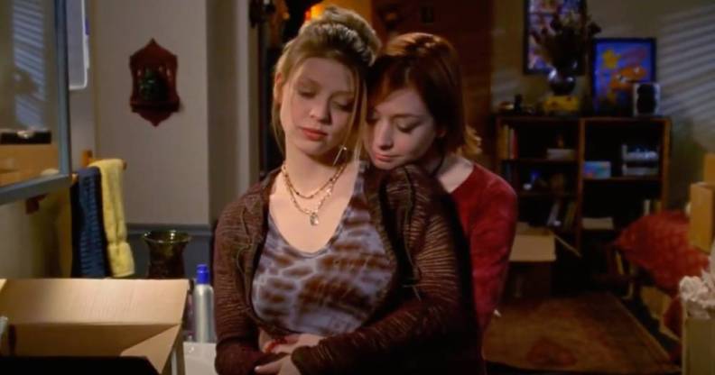 Buffy the Vampire Slayer character Willow holds Tara from behind
