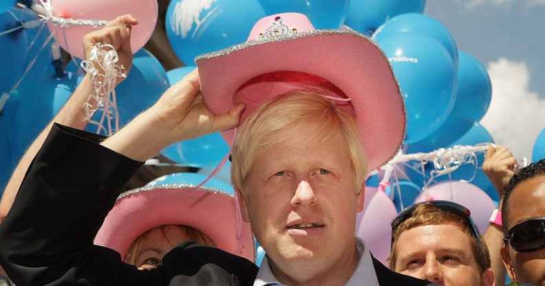Boris Johnson wearing a pink stetson in front of blue, pink and white balloons