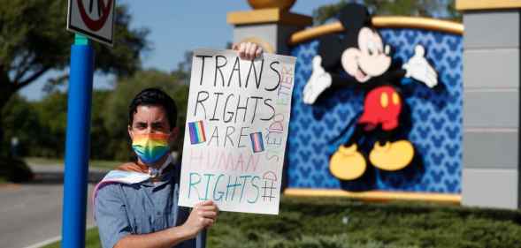 A Disney holds a sign while protesting outside of Walt Disney World on March 22, 2022 in Orlando, Florida.