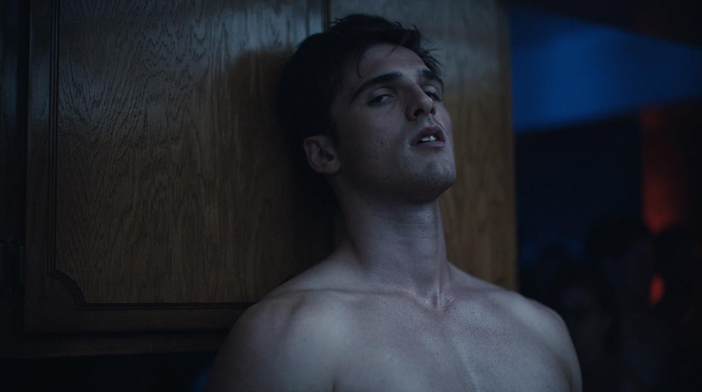 Jacob Elordi as Nate in Euphoria, standing topless against a wall