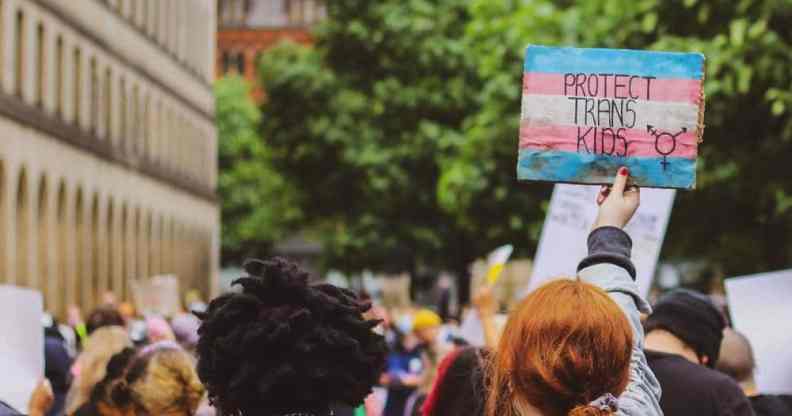 Person holds a sign that reads "Protect trans kids"