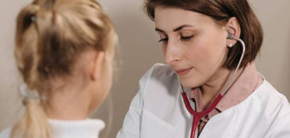 A doctor listens to the heartbeat of a young client
