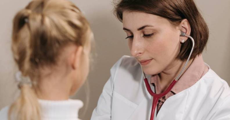 A doctor listens to the heartbeat of a young client