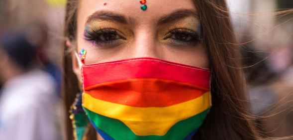 A person wearing a rainbow face covering