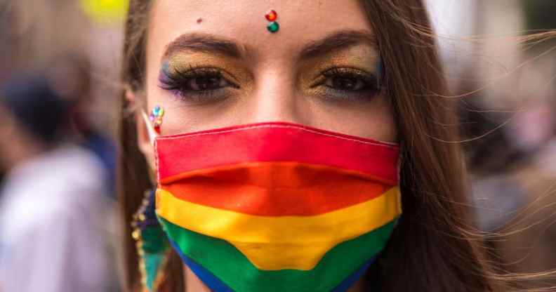 A person wearing a rainbow face covering
