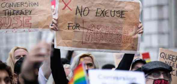 A protester holds a placard saying "No excuse for abuse" during a demonstration against conversion therapy outside UK Cabinet office