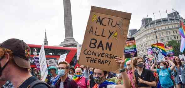 A demonstrator holds a placard that says "Actually Ban Conversion Therapy" in Trafalgar Square during the Reclaim Pride protest