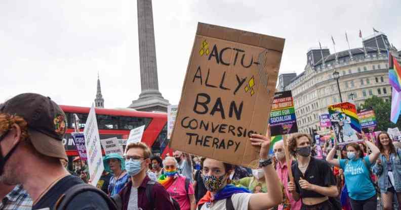 A demonstrator holds a placard that says "Actually Ban Conversion Therapy" in Trafalgar Square during the Reclaim Pride protest