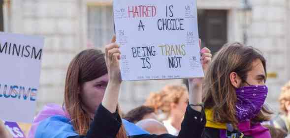 A protester holds a placard that says "Hatred is a choice, being trans is not" during a trans rights demonstration