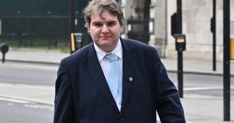 Conservative MP Jamie Wallis walks down the street wearing a white shirt, light blue tie and a suit jacket