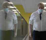 Boris Johnson walks through a hospital corridor