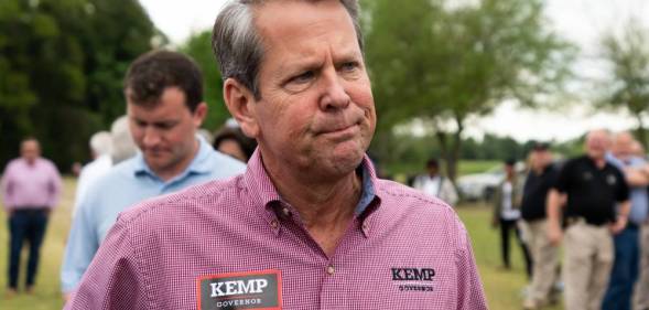Georgia govenor Brian Kemp wears a pinkish red patterned shirt which has tags reading 'Kemp govenor'