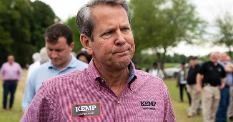 Georgia govenor Brian Kemp wears a pinkish red patterned shirt which has tags reading 'Kemp govenor'