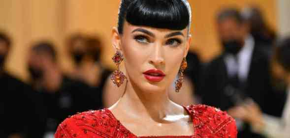 Megan Fox wears a red dress with red earrings and matching lipstick
