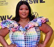 Lizzo wears a colourful, rainbow block outfit as she stands in front of a yellow background with the black SXSW logo on it