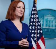 Jen Psaki stands in front of a US flag while attending a press conference at the White House