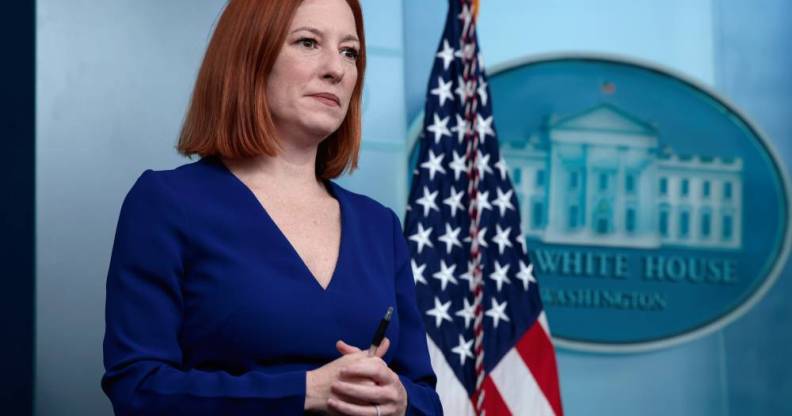 Jen Psaki stands in front of a US flag while attending a press conference at the White House