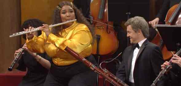 Lizzo plays the flute as she twerks during a skit on Saturday Night Live