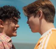 A still of Heartstopper characters Charlie and Nick on the beach from the Netflix show