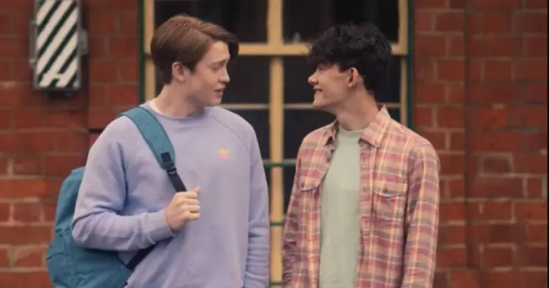 Actors Kit Connor and Joe Locke play characters Nick Nelson and Charlie Spring in the Netflix series Heartstoppers. In the scene, they are standing at a train station.