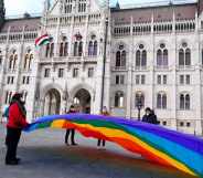 LGBT+ activists hold a 30 metre Pride flag in front of the Hungarian parliament building